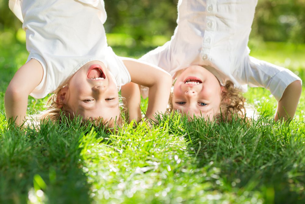 Kids doing handstands on grass